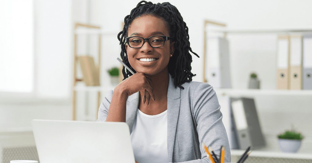 Business woman smiles as she works at her desk