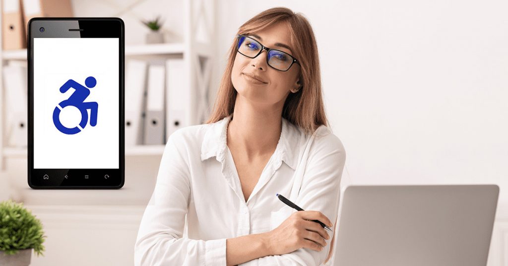 Smiling business woman stands in front of her laptop as a mobile phone with a disabled sign floats to her right